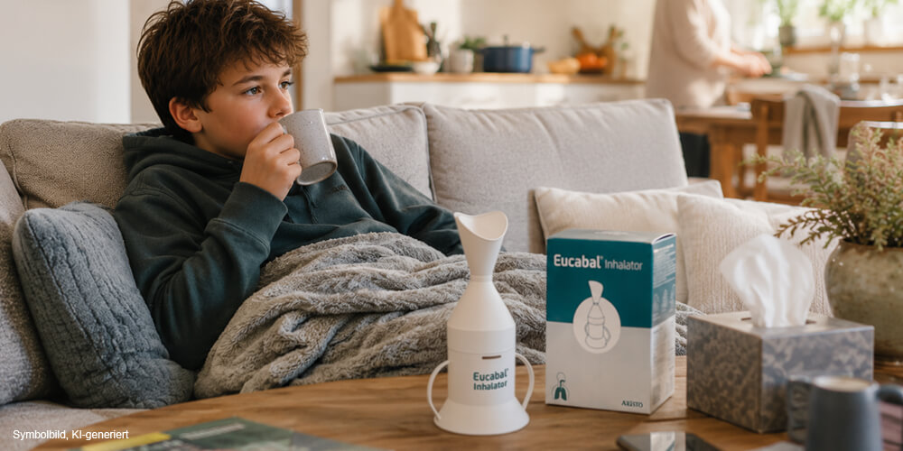 erkältetes Kind auf Sofa mit Eucabal Inhalator auf Tisch stehend